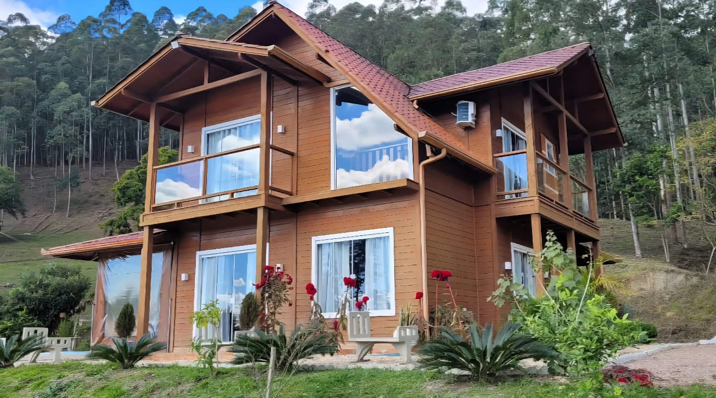 Casa Bosque: casa de madeira de 152 m² com dois pavimentos, sacadas e grandes janelas