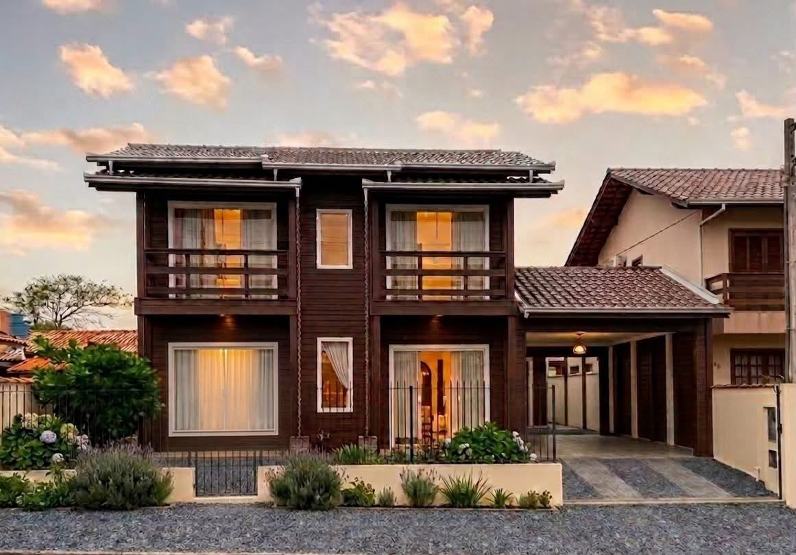 Casa Duo: sobrado de madeira escura de 111 m² com duas sacadas e garagem coberta