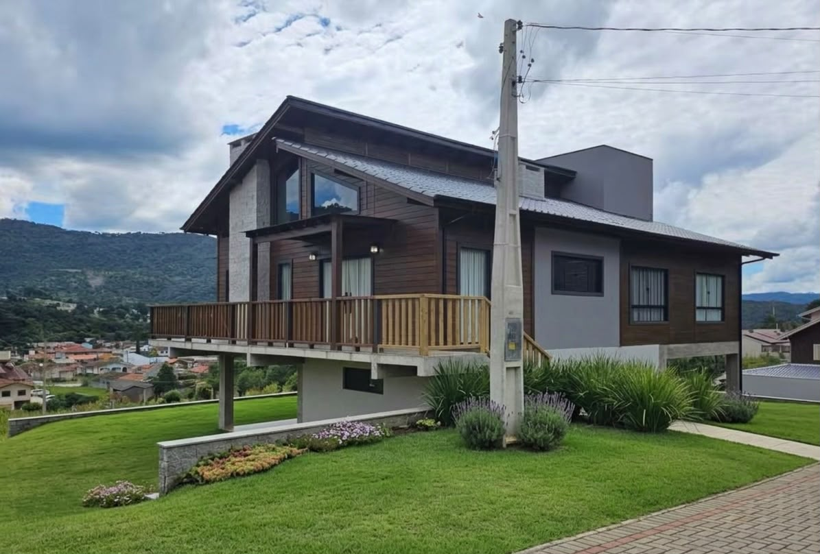 Casa Montanha: casa de madeira de 80 m² sobre pilares com deck e vista para a serra