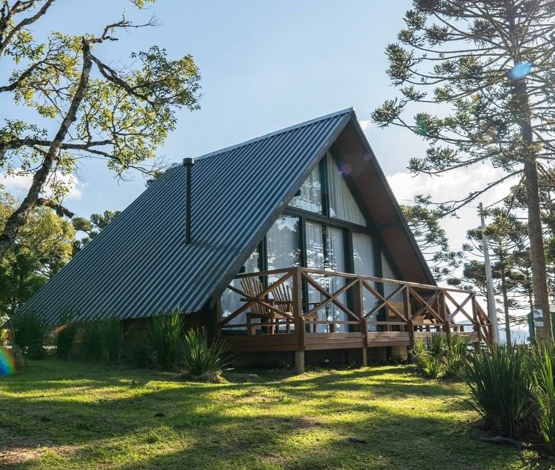 Casa em formato A-frame com varanda de madeira
