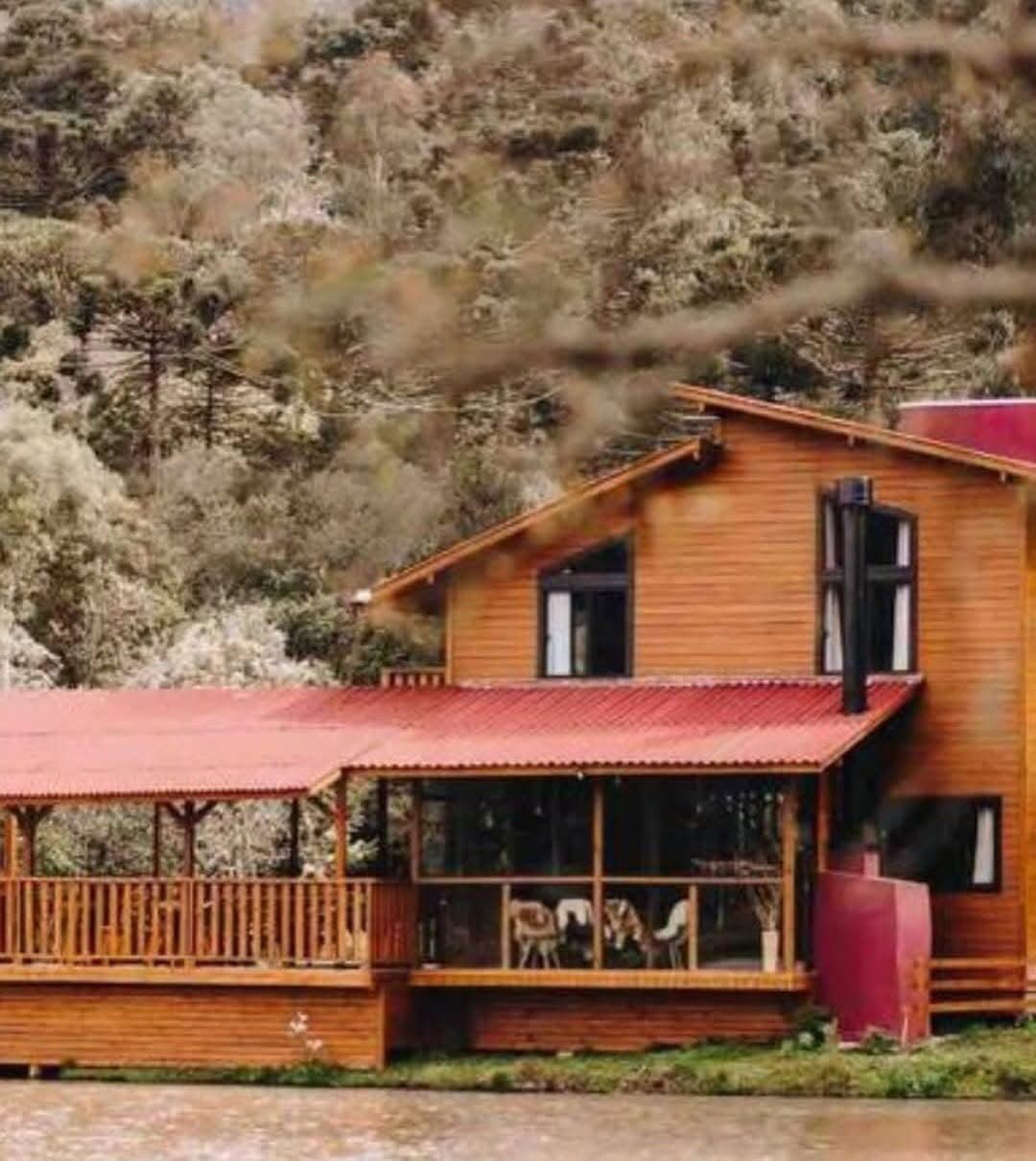 Casa de madeira com varanda ampla à beira do lago